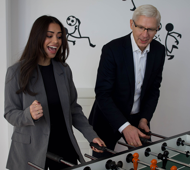 Mitarbeitende spielen am Tischfußball in der comramo